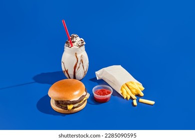 Tempting combo meal with burger, fries, sauce, and milkshake on a blue background. Minimalist style showcases fast food in a modern, unhealthy way. - Powered by Shutterstock