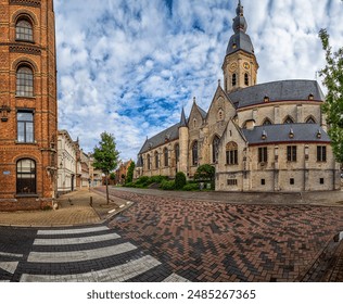 Temse, Belgium - A street in Belgium with a historic church, brick buildings, and a cobblestone road. - Powered by Shutterstock