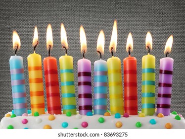 Ten colorful candles on gray background