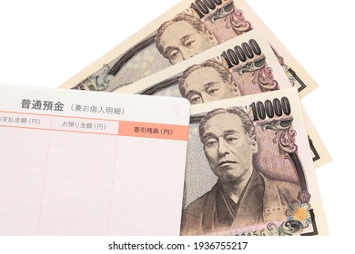 Ten thousand Japanese yen with passbook isolated on white background. Translation: Ordinary bank account, Payment, Deposit, Balance. - Shutterstock ID 1936755217