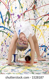 Ten Year Old Girl Doing Back Bend Towards Camera On Paint Splashed Background.  Full Body.