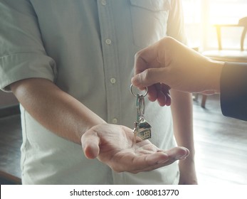 Tenant With The Landlord. Home Salesmen Are Looking At Home Keys To Buyers According To A Rental Agreement.