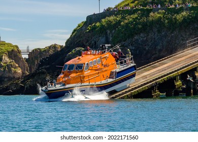 TENBY, WALES - JUNE 15 2021: The RNLI Tamar class offshore lifeboat "Haydn Miller" launches from the slipway at the lifeboat station in the resort town of Tenby, Pembrokeshire, Wales