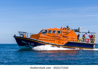 TENBY, WALES - JUNE 15 2021: The RNLI Tamar class offshore lifeboat "Haydn Miller" launches from the slipway at the lifeboat station in the resort town of Tenby, Pembrokeshire, Wales