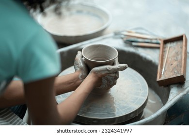 With tender care and determination, an African American boy nurtures his clay artistry, shaping and molding clay with precision and creativity in the supportive ceramic workshop. - Powered by Shutterstock