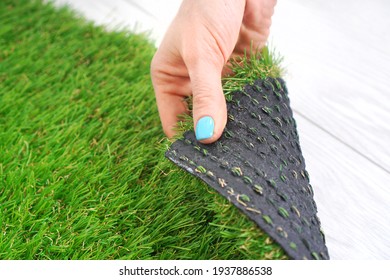 Tender Female Hand Touching An Artificial Turf Roll