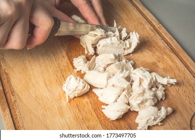 Tender Hands Of The Girl Cut With Knife Boiled Chicken Breast For Salad On Wooden Board