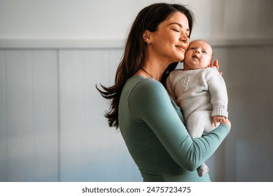 Tender happy mother hugging her newborn baby. Family, parenting baby single mother love concept.