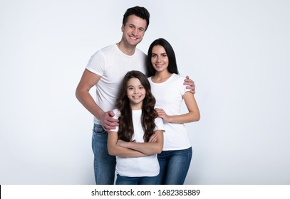 Tender Hug. Beautiful Excited And The Funny Family Team Is Posing In A White T-shirt While They Isolated On White Background In Studio.