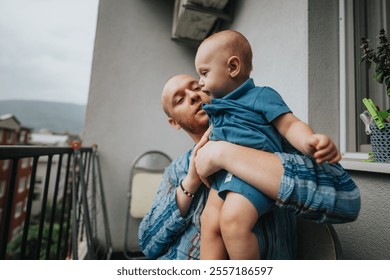 A tender moment of a father and baby sharing a special bond on a balcony. The image conveys warmth and family togetherness with a serene outdoor backdrop. - Powered by Shutterstock