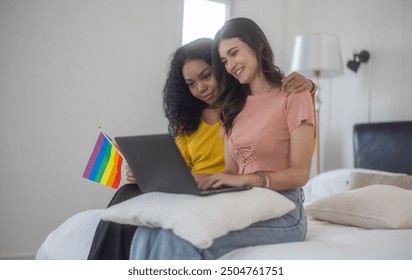 Tender moment of lesbian couple relaxing on bed, They enjoy browsing tablet together.  The Cozy bedroom setting adds to the intimate and warm atmosphere - Powered by Shutterstock