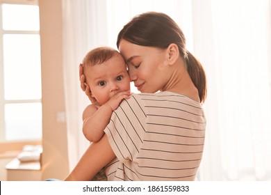 Tender moment. Mother enjoying great time with her lovely baby, while holding him at her hands and bonding with tenderness. Motherhood and happy chidhood concept