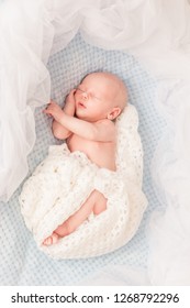 Tender Newborn Sleeping On Belly On A Blanket In Cute Props. Infant Baby