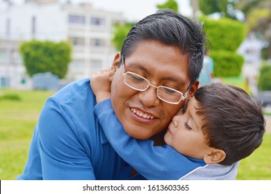 Tender Portrait Of Native American Man With His Little Son In The Park.