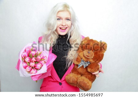 tender pretty blonde slim teen girl with pink flowers. cheerful woman with fresh bouquet