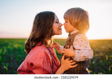 Tender Scene Of Loving Son With Mom On Sunset Backdrop. Beautiful Family. Cute 3 Year Old Kid With Mother. Parenthood, Childhood, Happiness, Children Wellbeing Concept.