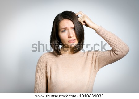 tender woman remembers something, in a pink sweater, isolated against a background, studio photo