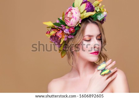 tender young woman posing in flower wreath with artificial  greenbutterfly,  isolated on ochet background