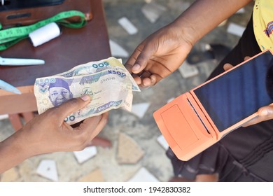 Tendering Nigerian Naira Note In A Cash Transaction With The Help Of Point Of Sales POS  Terminal In A Tailoring Fashion Designing Shop