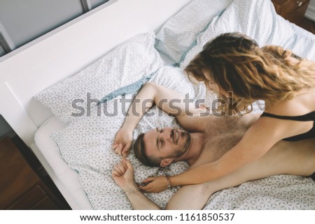 Similar – Young couple in love embracing lying over a bed