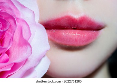 Tenderness rose. Pink lips with pink rose. Tenderness woman. Concept of caring and tenderness