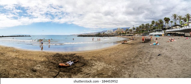 TENERIFE, SPAIN - AUGUST 28, 2013: Unidentified Tourists Relaxing At Playa De Las Americas In Tenerife.  Playa De Las Americas Is A Centre Of Nightlife In Tenerife.