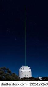 TENERIFE, SPAIN - JANUARY 25, 2019: Laser guide star tests at the Teide Observatory in a starry night. The laser beam is clearly visible at naked eye.