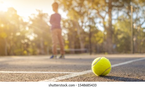 Tennis ball close-up photo on outdoor court with player on background in South Australia