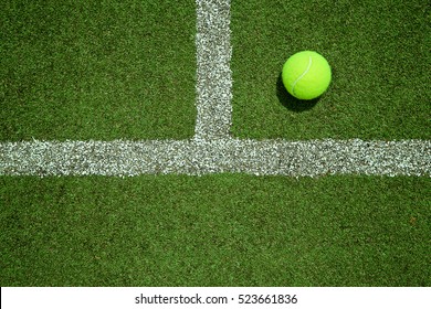 Tennis ball near the line on tennis grass court from top view. Good for background