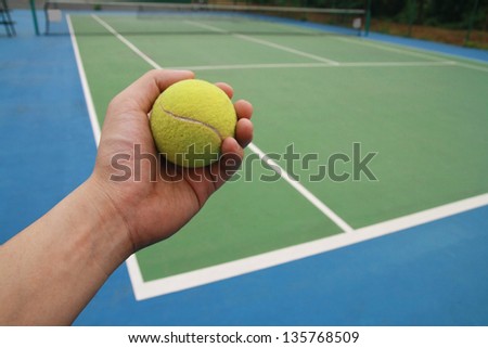 tennis ball on  player hand, tennis ball on green blue court and net, sport competition background, sport club