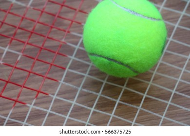 Tennis Ball On Racket Net On Wood Background