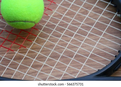 Tennis Ball On Racket Net On Wood Background