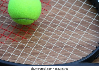 Tennis Ball On Racket Net On Wood Background