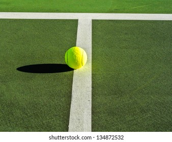 A tennis ball on the white line