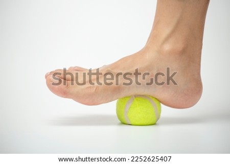 Tennis ball roll massage for plantar fascia stretch. Foot muscle exercises.