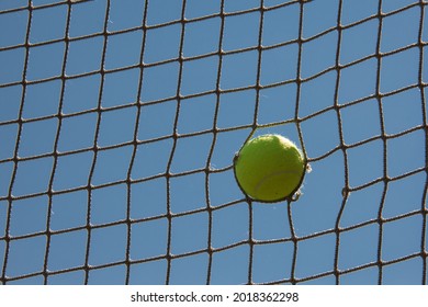 Tennis Ball Stuck In An Old Tennis Net After A Strong Ace. Selective Focus. High Quality Photo