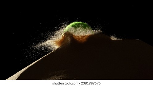 Tennis ball throw hit sand soil and Deep impact on sand hill and splash all over area. Tennis ball hit Sand dune hill over wind storm and blast dust splash over mountain. Black background isolated - Powered by Shutterstock