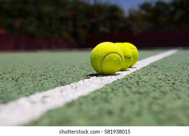 Tennis balls on a green tennis hard court