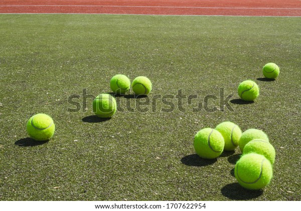 tennis\
balls on a sports green covering of a tennis\
field