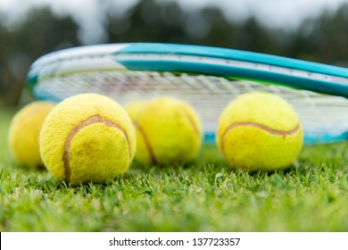 Tennis balls with a racket at the lawn court
