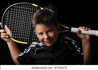 Tennis boy smiling isolated in black