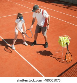 Tennis Coach Instructing Young Talented Girl