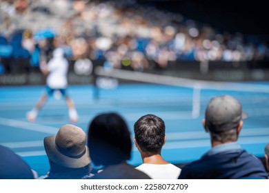 Tennis crowds watching a tennis match. Crowd watching a sporting match.