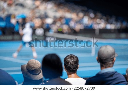 Tennis crowds watching a tennis match. Crowd watching a sporting match.