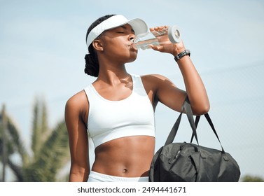 Tennis, drinking water and black woman on court, sports and fitness with nutrition, wellness and workout. African person, outdoor and athlete with bottle racket and training with break and healthy - Powered by Shutterstock