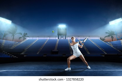 Tennis girl on a professional tennis court in night. - Powered by Shutterstock