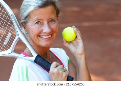 Tennis is my favorite sport. Attractive senior woman in sportswear holding a tennis racquet and ball. - Powered by Shutterstock