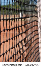 Tennis Net Close Up With Tennis Court And Trees In The Background