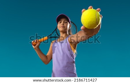 Tennis player. Beautiful girl teenager and athlete with racket in pink sporswear and hat on tennis court. Fashion and sport concept.