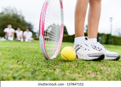 Tennis player at the court with racket and a ball